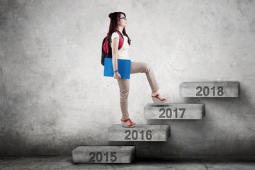 Student walks toward 2017 on stairs