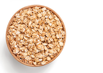 Healthy oat flakes in wooden bowl isolated on white background. Close up, top view, copy space, high resolution product