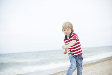 smiling boy walks on the beach