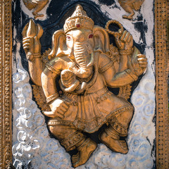 golden Ganesha god of success with offers in the wall with red eyes.