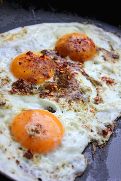 Fried eggs in with red hot chilly peppers
