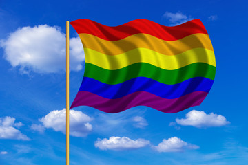 Rainbow gay pride flag wavy on blue sky background