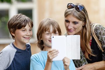 Two Boys Showing Something to Mother on Tablet © courtyardpix