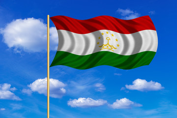 Flag of Tajikistan waving on blue sky background