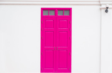 traditional Pink door wooden of an old on white wall,in Thailand