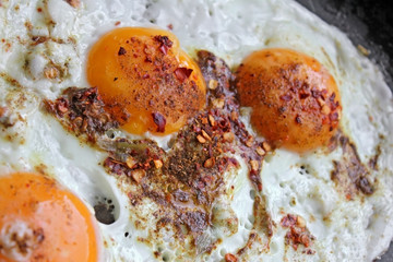 Fried eggs in with red hot chilly peppers