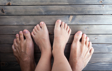 barefoot, feet on wooden parquet floor, adult and child, family.