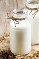 Fresh cow milk or cream in glass bottles, rustic style, vintage