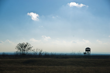 Naklejka premium Hunting watchtower on a meadow at sunny autumn day, Deliblatska pescara, Serbia