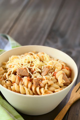 Rotini pasta with tuna and tomato sauce and grated cheese on top, photographed with natural light (Selective Focus, Focus in the middle of the dish)
