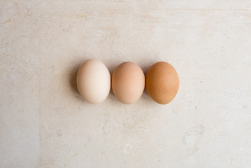 High angle view of three eggs on natural limestone background