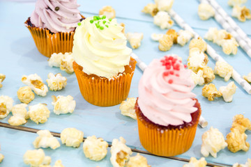 Pink frosted cupcakes on light blue background