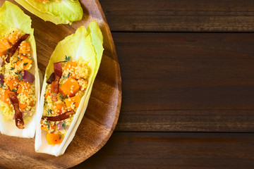 Endive leaves filled with a salad of couscous, pumpkin, red onion and bacon, photographed overhead...