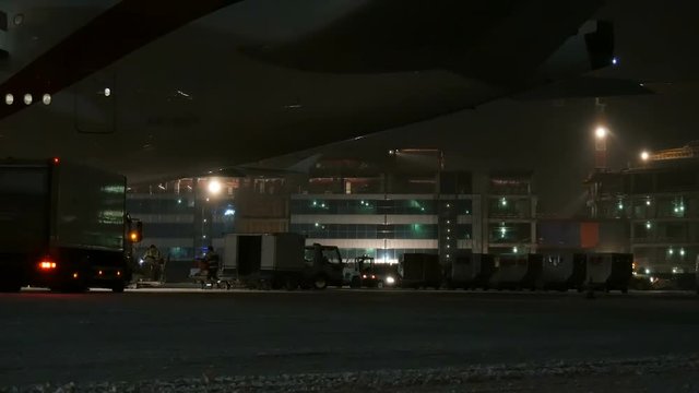 The aircraft receives service at the airport. At night.