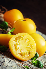 Cut large yellow tomatoes and green leaves of basil, vintage woo