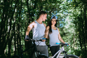 Fototapeta na wymiar Young Couple Riding Bike In Park
