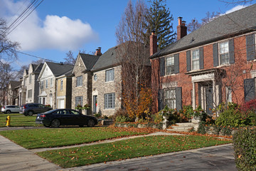 front yards and driveways of street with suburban houses
