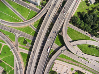 Aerial view at junctions of interchange of urban highway. Vehicles drive on roads. Russia