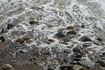 Coastal pebbles in the surf. Crimea.