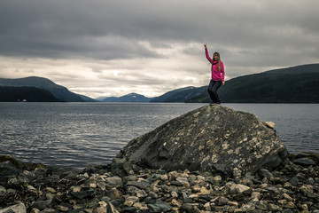 Young woman is dancing on the stone, Norway