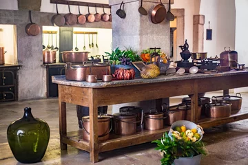 Photo sur Plexiglas Château Kitchen of medieval castle copper pans and pots on wall and  kitchenware cooking utensils table, Pena Portugal