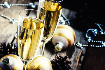 Dry Champagne in glasses, Christmas golden balls, pine cones, Ne