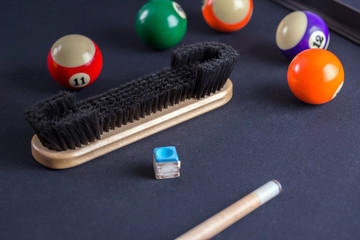 Brush for cleaning of billiard table with cue and balls.