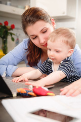 Obraz premium Young mother working with her baby at home