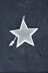Merry Christmas star on black wooden background