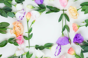 Pink, white and violet eustoma flowers stems floral flat lay frame