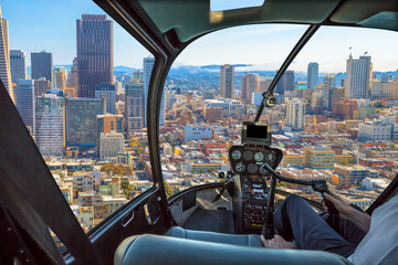 Fototapeta na wymiar Helicopter cockpit flies in San Francisco Financial District Downtown, California, United States, with pilot arm and control board inside the cabin.