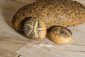 Small breads with poppy seeds and Wheat on wooden background