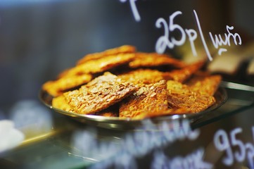 Delicious sweet pastries on a tray in the showcases, beautiful blurred background