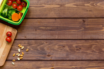 green lunch box for kid on wooden background top view