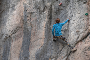 Young girl climbing up the rock in Turkey