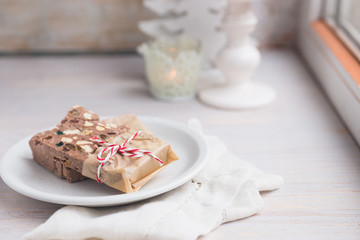 Festive chocolate block tied with string with festive winter decor in the background.