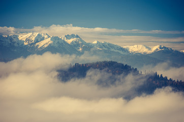 Fototapeta na wymiar Snowy Tatra mountains over clouds, Poland