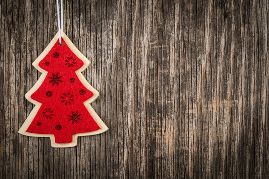 Red Christmas tree over rustic wood and copy space
