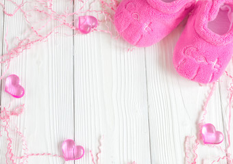 pink baby's bootees on wooden background
