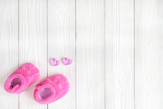 pink booties on wooden background