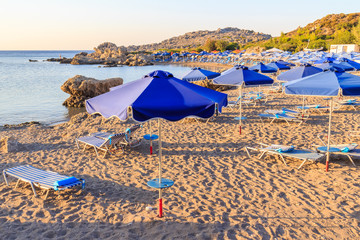 Color sun umbrellas and loungers on the beach