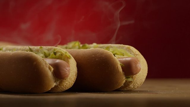 Appetizing steaming hot dog on red background. Shot on RED EPIC DRAGON Cinema Camera.