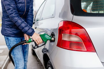 Woman refueling her small silver car