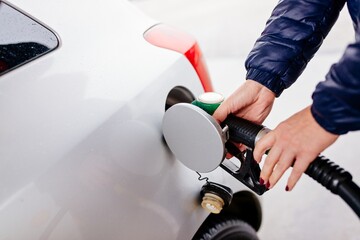 Woman refueling her small silver car