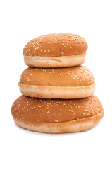 Stack of burger buns with sesame seeds on white background