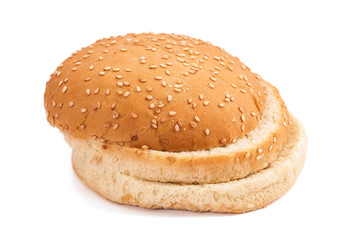 Burger bun with sesame seeds on white background