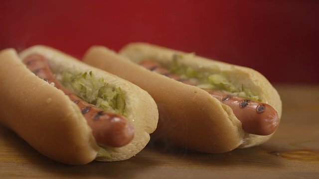 Appetizing steaming hot dog on red background. Shot on RED EPIC DRAGON Cinema Camera.