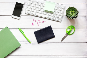 female wooden desktop with smartphone, notebook and flowers top view