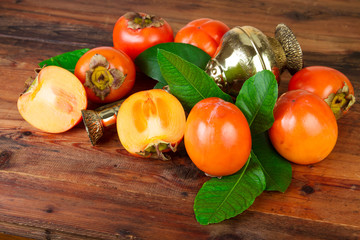 Persimmons kaki fruits with vintage brass vase. Oriental East Persian still life.