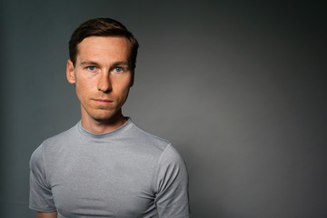 Young man in t-shirt on gray background.